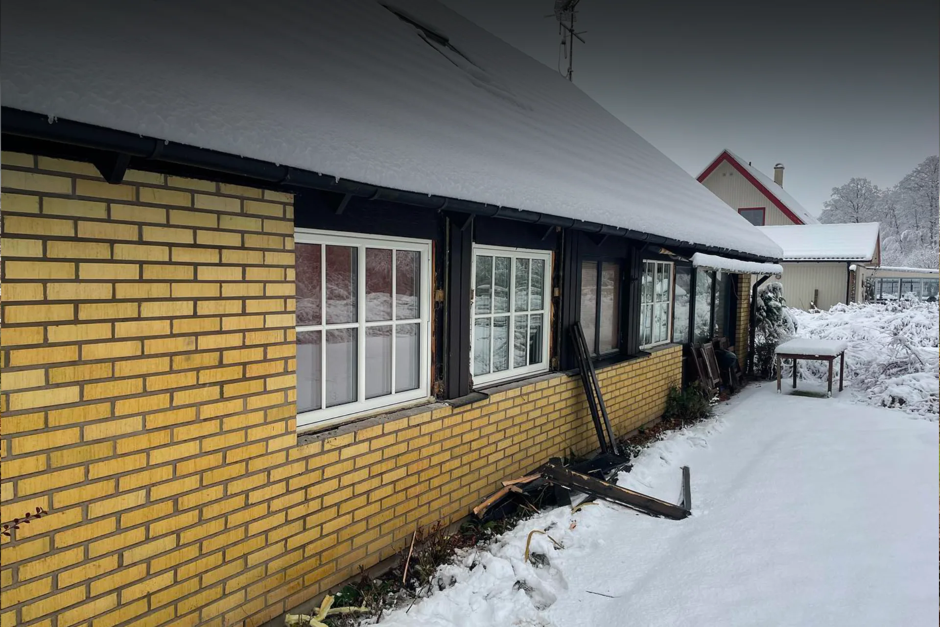 Gult hus med snö på taket